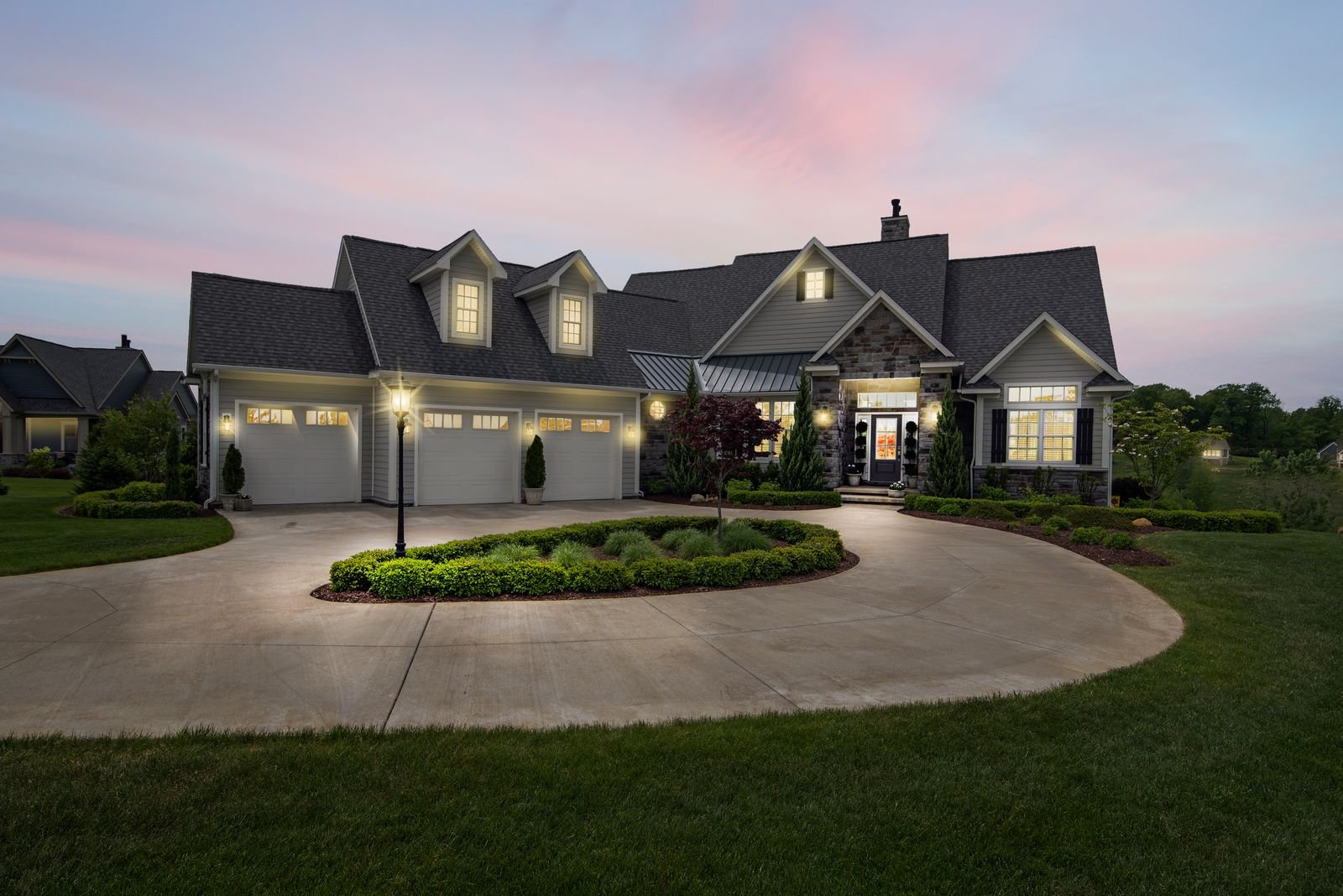 Modern American home in Austin, Texas with a newly installed charcoal architectural-shingle roof, photographed at dusk with warm interior lighting