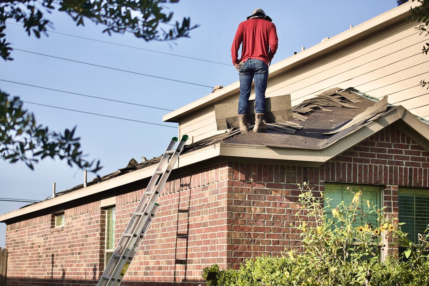 Roofer conducting a rooftop inspection overlooking a neighborhood