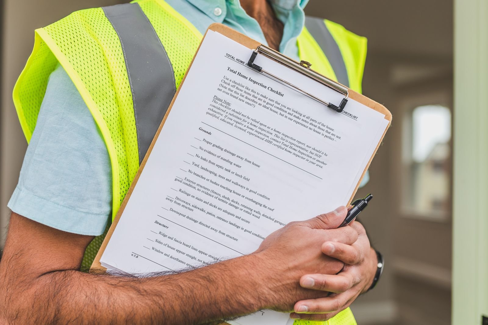 Northline Roofing technician inspecting a residential roof with a clipboard, wearing branded workwear